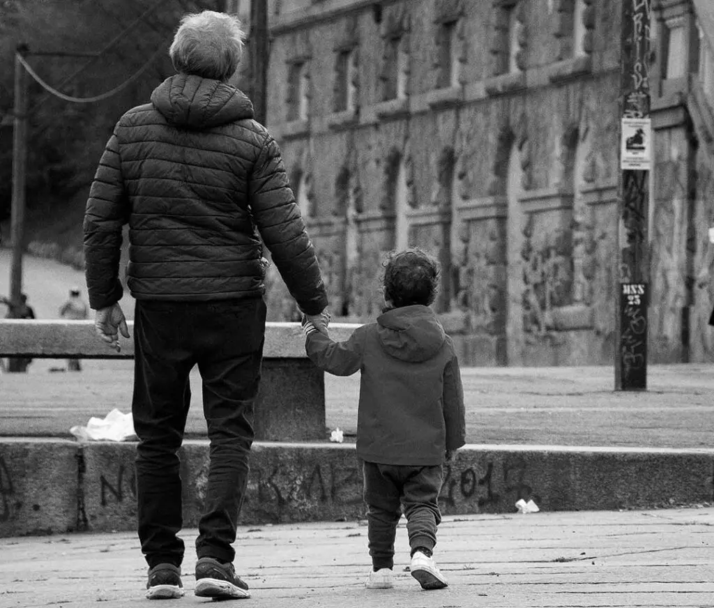man and child walking hand-in-hand