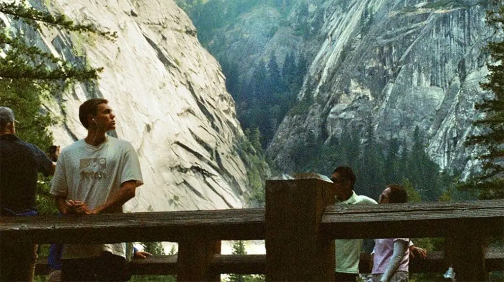 people on a bridge looking at mountains